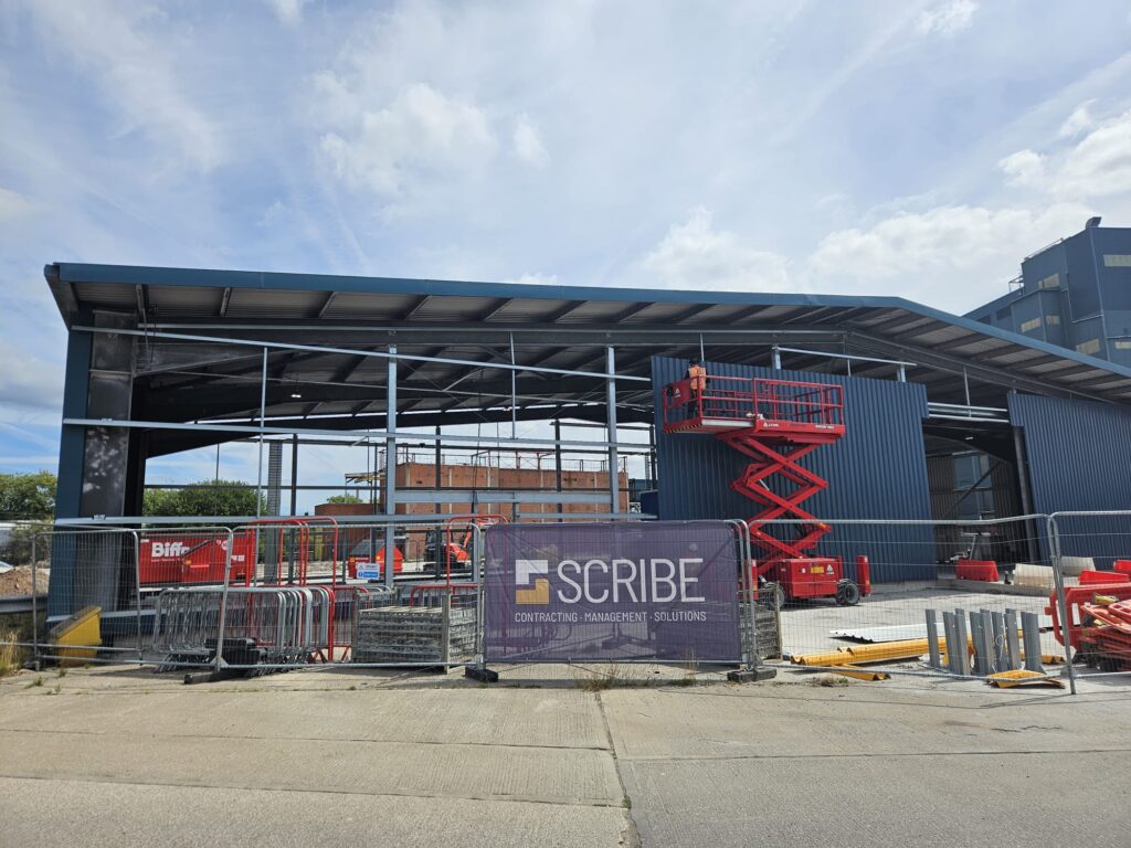 Warehouse under construction in Warrington, undertaken by Scribe Construction Management Services, showing safe access platform and workers completing fitting